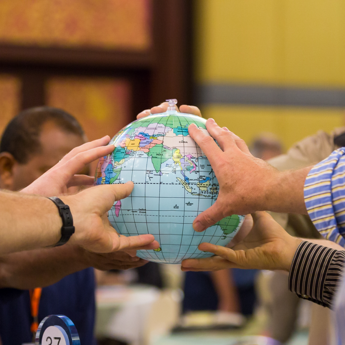 A group of people holding a globe while praying